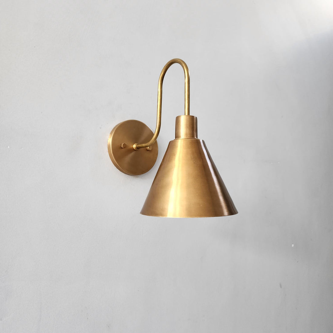 Handcrafted brass wall sconce with cone shade