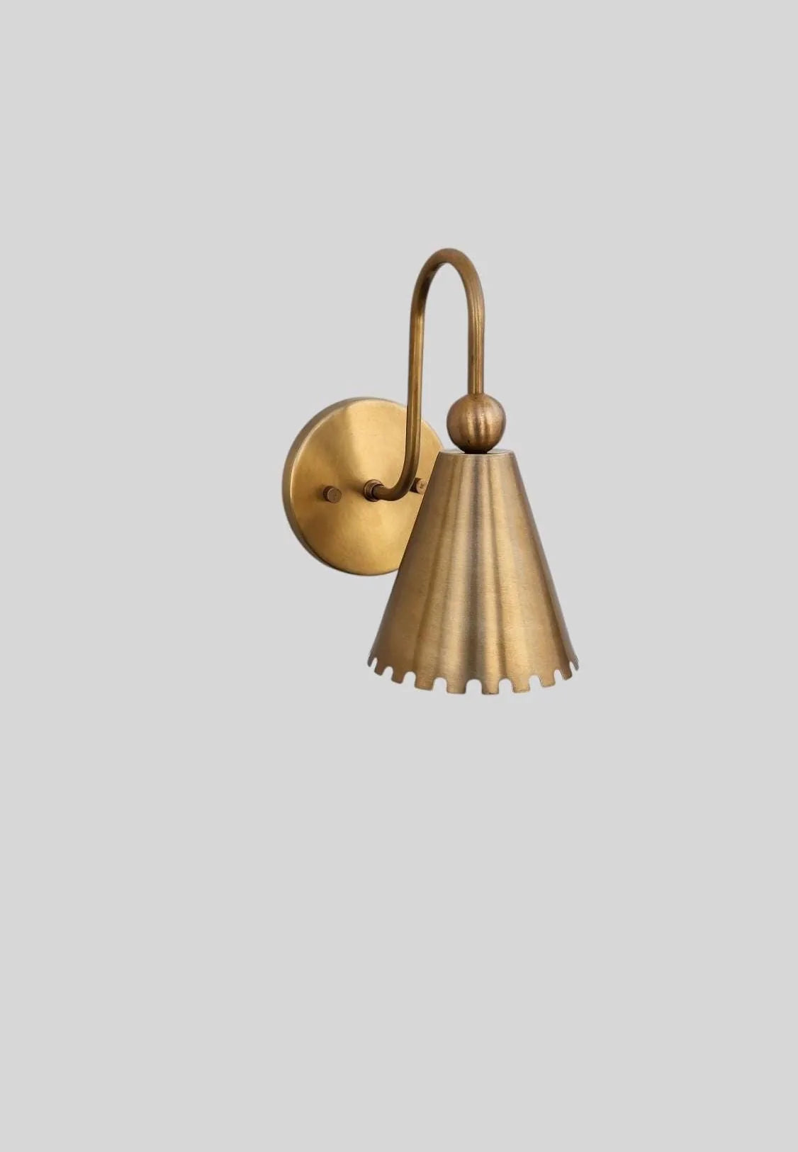 Brass wall sconce on a light gray background