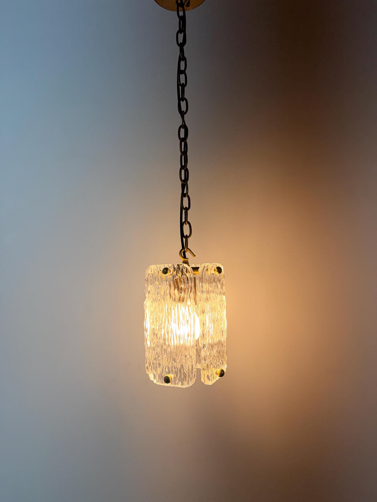 Classic textured glass pendant lighting with elegant brass hardware and chain.