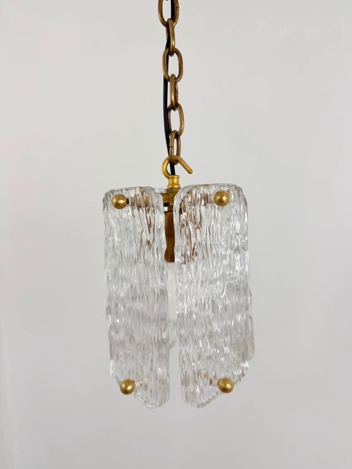 Clear textured glass hanging pendant light with polished brass hardware.
