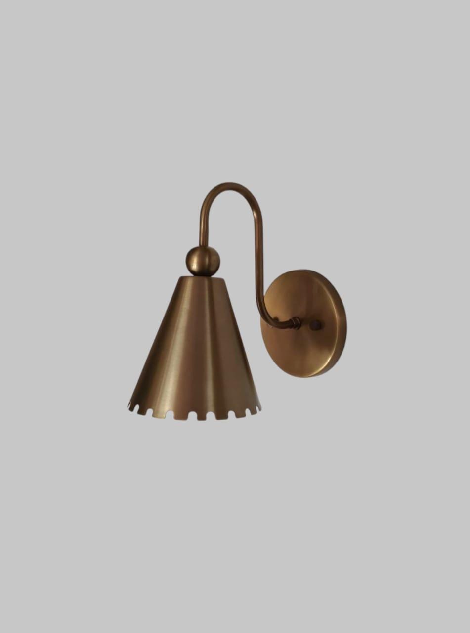 Elegant handcrafted brass wall sconce with vintage floral design showcased in a cozy living room setting.