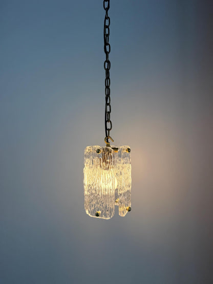 Elegant textured glass pendant lamp featuring brass details and chain hanging.
