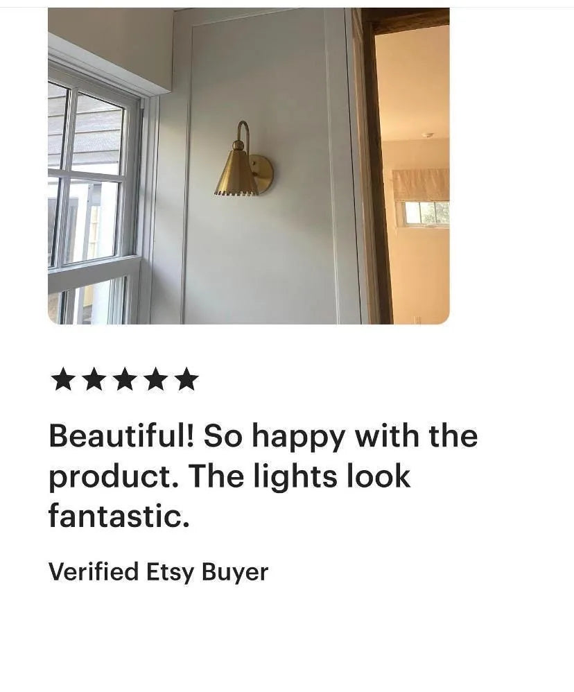 Gold wall sconce on a white wall with a five-star rating and review text.