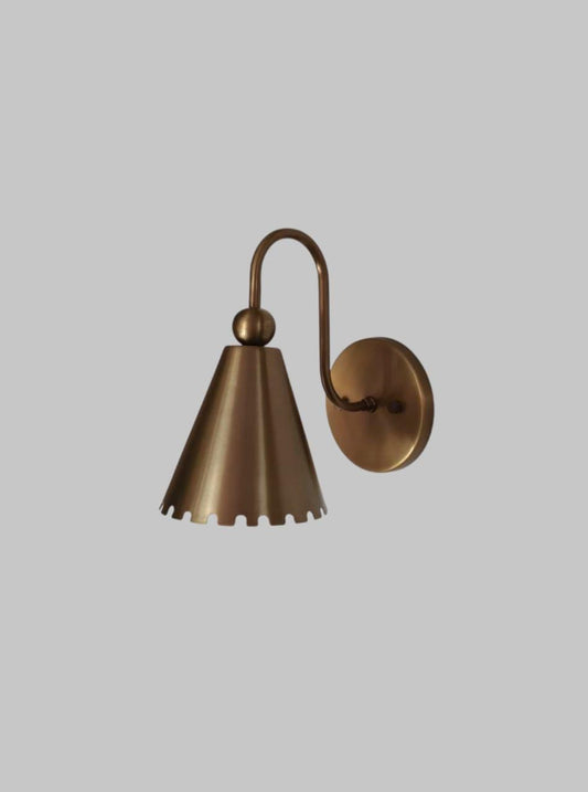 Elegant handcrafted brass wall sconce with vintage floral design showcased in a cozy living room setting.