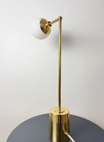 A Handmade Globe Lamp with An Adjustable Brass Arm Extending from A Slim Vertical Stem, Topped by A Rounded Opal White Glass Shade. the Compact Cylindrical Base Gives the Fixture a Neat Footprint for Bedside, Desk, and Side Table Placement, Frost Lights.