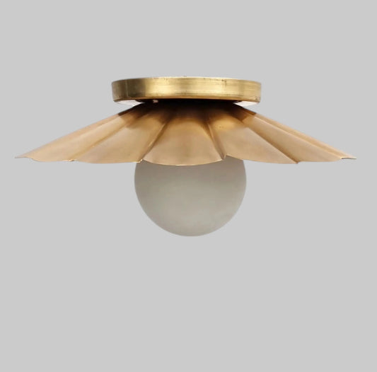 Vintage brass chandelier with a scalloped shade and frosted bulb, ideal for elegant floral-themed decor.