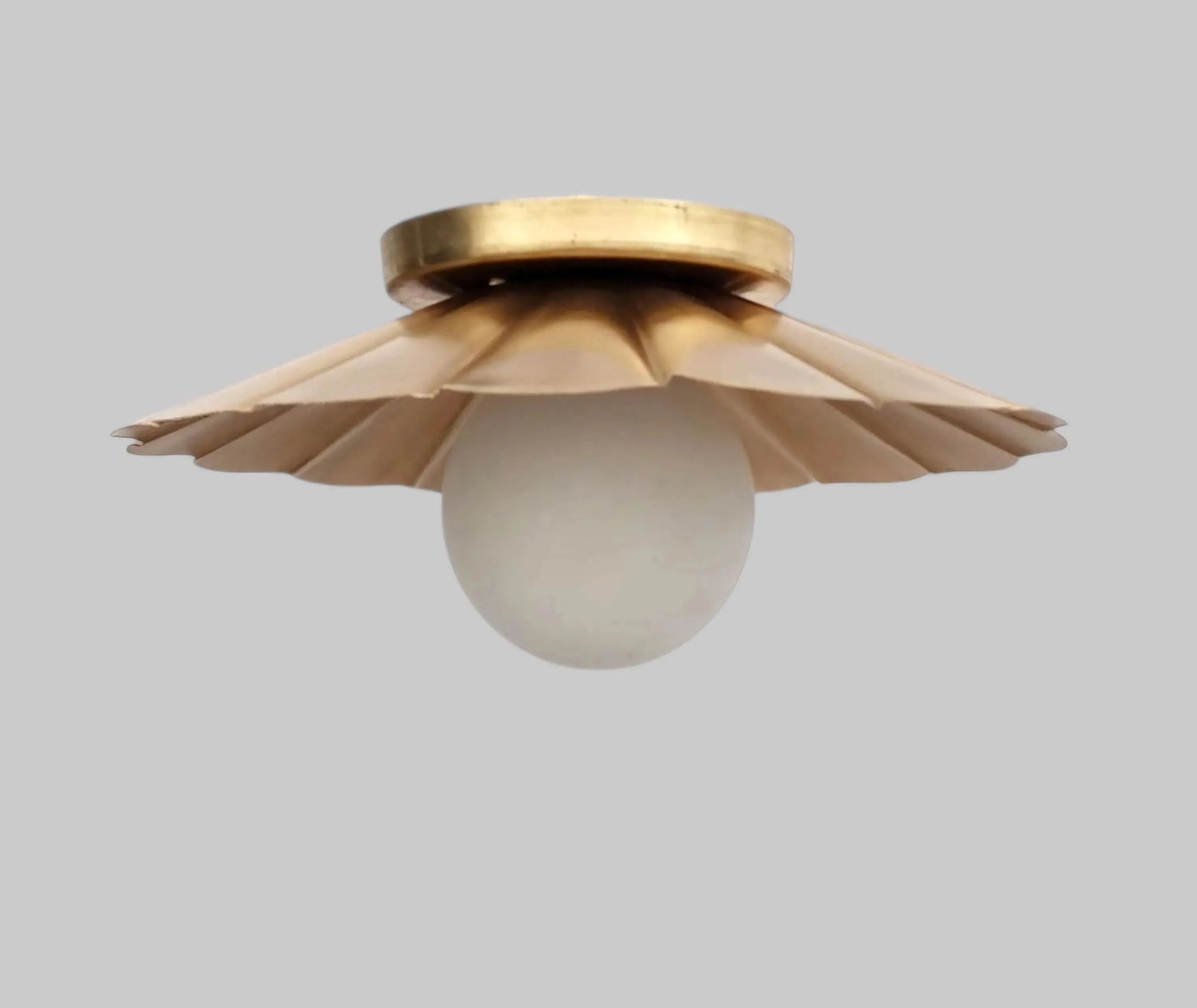 Vintage brass chandelier with a floral design and frosted glass globe, perfect for elegant ceiling lighting.