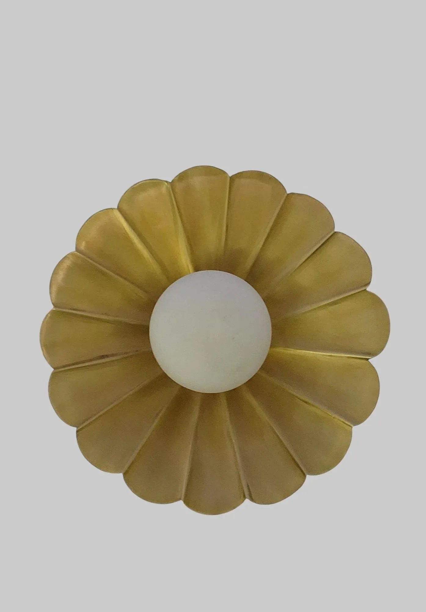 Vintage brass chandelier featuring floral petal design with a white globe center, ideal for elegant ceiling decor.