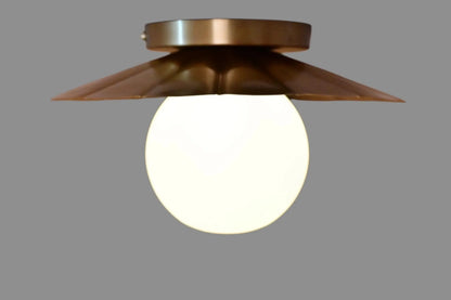 Vintage brass chandelier with a floral design, featuring a white glass globe and a sleek, elegant silhouette.
