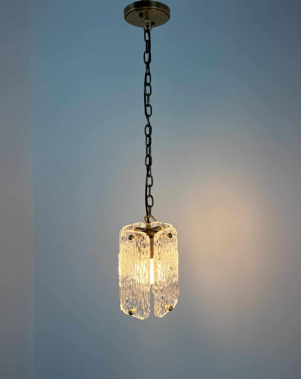 Stylish textured glass pendant ceiling light with brass trim and chain suspension.