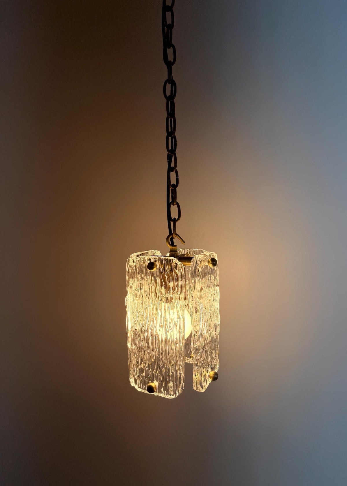 Stylish textured glass pendant ceiling light with brass trim and chain suspension.