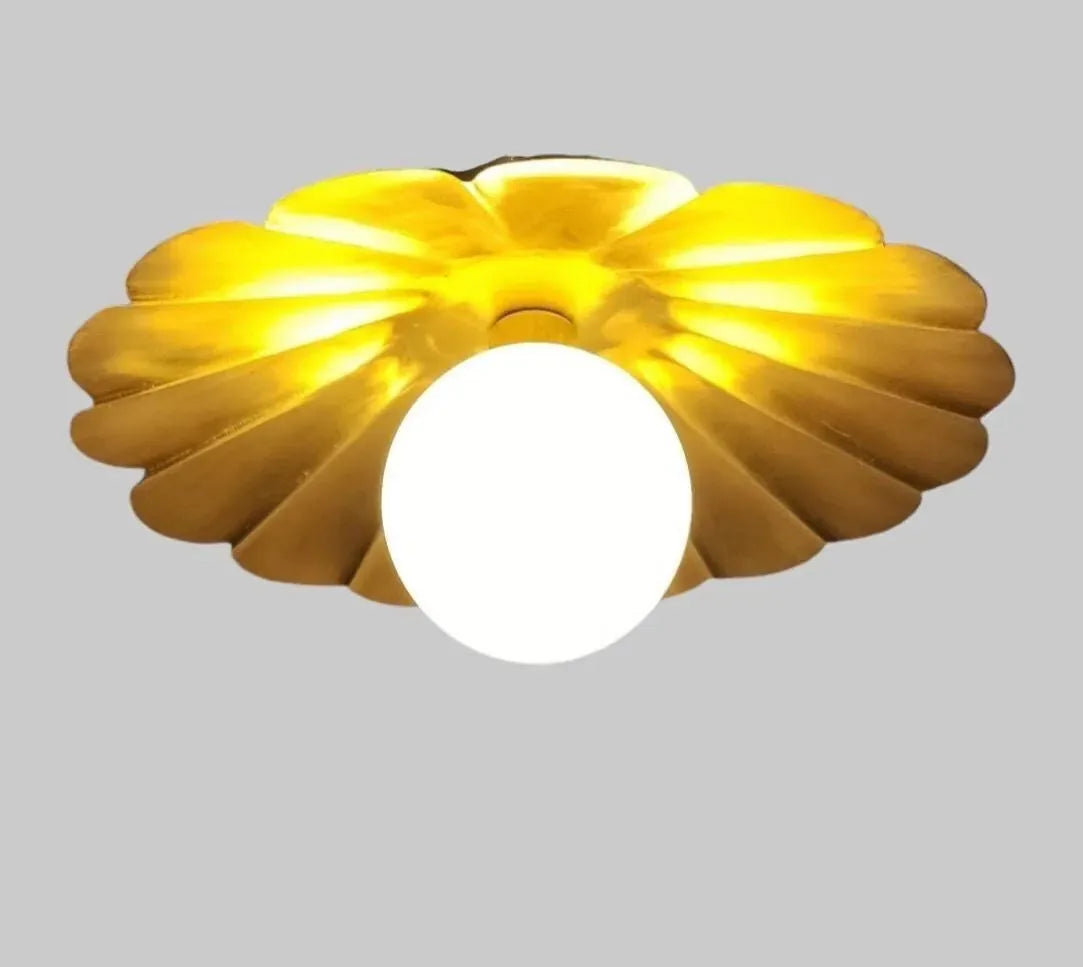 Vintage brass chandelier with a floral design, features a central round bulb and soft ambient lighting.
